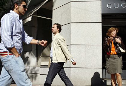 Viandantes frente a una tienda de lujo en Madrid | Alamy