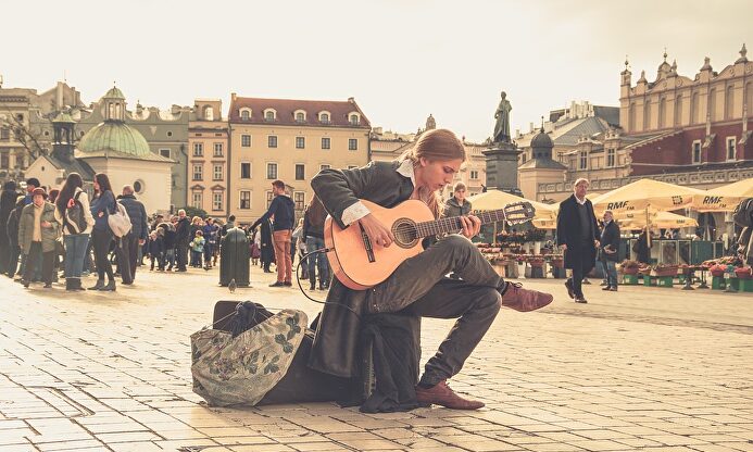Un joven toca la guitarra en una plaza de Polonia | Pixabay