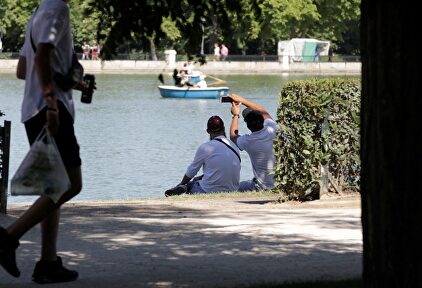 La gente busca sombra en el Parque del Retiro, en Madrid | EFE