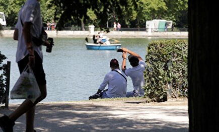 La gente busca sombra en el Parque del Retiro, en Madrid | EFE