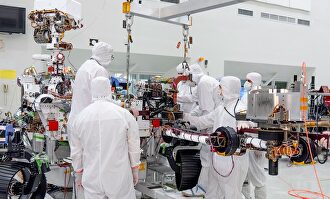 Empleados de la NASA trabajando con un brazo robótico | NASA-JPLCALTECH