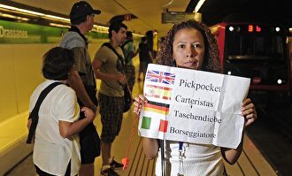 Eliana Guerrero con un cartel avisando a los turistas de la presencia de carteristas (Barcelona) | Wikimedia