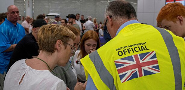 Empleados del gobierno británico atieden a los pasajeros en el aeropuerto de Palma de Mallorca. | EFE