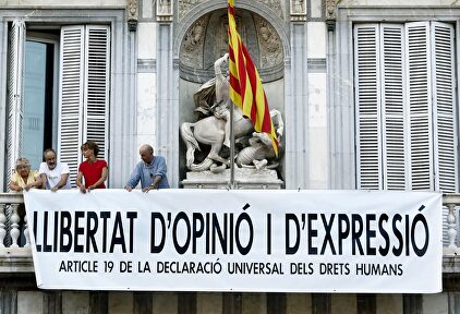El cantante Lluis Llach, el exdiputado Antonio Baños y la actriz Silvia Bel colocan la nueva pancarta | EFE EFE