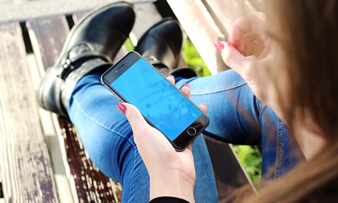 Una joven con un teléfono en la mano. |  Pixabay/CC/JESHOOTS-com