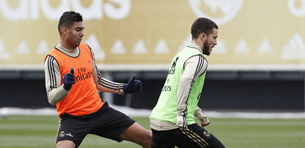 Hazard conduce la pelota en el entrenamiento ante Casemiro. | Realmadrid.com