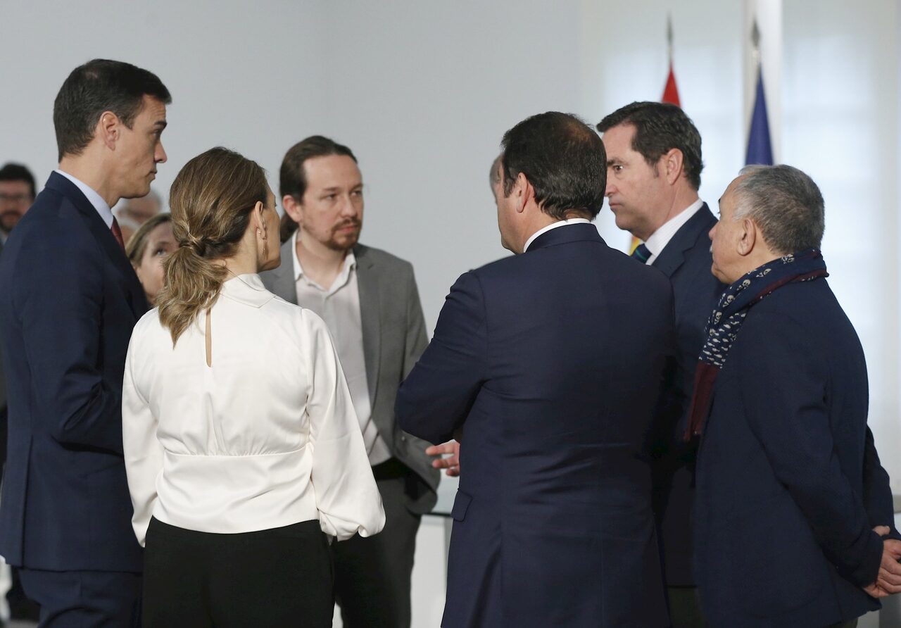 Yolanda Díaz (de espaldas) y Antonio Garamendi, junto a Pedro Sánchez y Pablo Iglesias, tras la firma del acuerdo sobre el SMI en Moncloa. | EFE