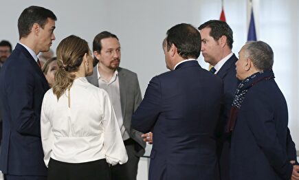 Yolanda Díaz (de espaldas) y Antonio Garamendi, junto a Pedro Sánchez y Pablo Iglesias, tras la firma del acuerdo sobre el SMI en Moncloa. | EFE