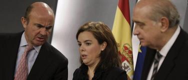 Fernández Díaz (d), junto a la vicepresidenta y Luis de Guindos. | EFE