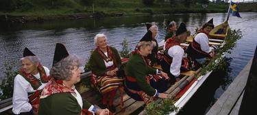 Varias mujeres celebran en un bote el solsticio de verano. | Corbis