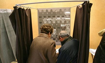 Dos señores en una cabina en un colegio electoral en Cataluña | Archivo