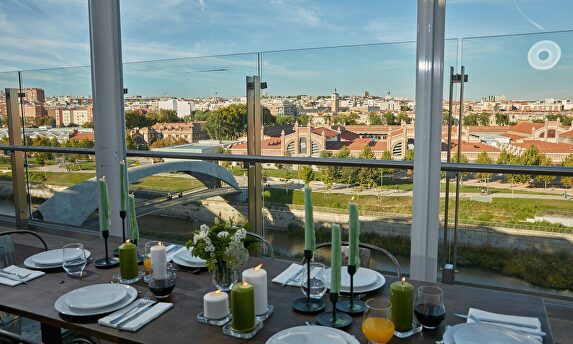 Un hombre ataviado con una mascarilla pasa por delante de una terraza recogida de un bar | EFE