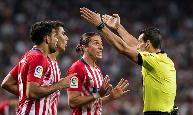 Varios jugadores del Atlético protestan en un encuentro. |  EFE