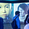Dos grandes pantallas muestran las caras de los robots más modernos, con rasgos totalmente humanoides.