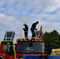 Dos bomberos subidos a su camión se preparan para el desfile del 12 de octubre.
