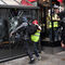Varios manifestantes de los llamados "chalecos amarillos" destroza a patadas el escaparate de un comercio en París.