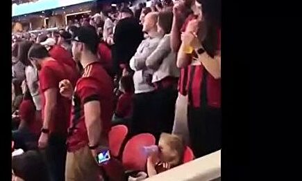 Un padre entretiene a su hija con dibujos animados para poder ver un partido