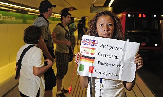 Eliana Guerrero con un cartel avisando a los turistas de la presencia de carteristas (Barcelona) |  Wikimedia
