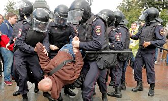 arios policías antidisturbios se llevan en volandas a un manifestante |  EFE