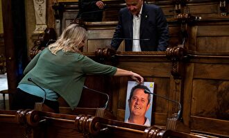Neus Munté coloca una fotografía de Joaquim Forn al inicio de la sesión extraordinaria por el Plenario del Consejo Municipal de Barcelona. |  EFE