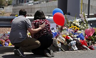 Personas dejen flores cerca al lugar del tiroteo. |  EFE