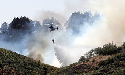 Uno de los nueve helicópteros que trabajan en las labores de extinción del incendio forestal en la localidad de Montaña Alta |  EFE