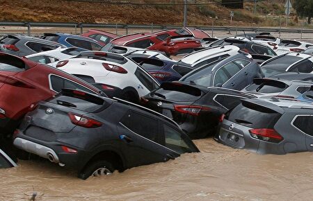 Cientos de coches inundados tras el paso de la Gota Fría en un depósito de vehículos en Orihuela |  EFE