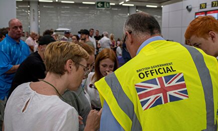 Empleados del gobierno británico atieden a los pasajeros en el aeropuerto de Palma de Mallorca. |  EFE