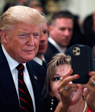 Trump posa para selfis en un acto este viernes. |  EFE