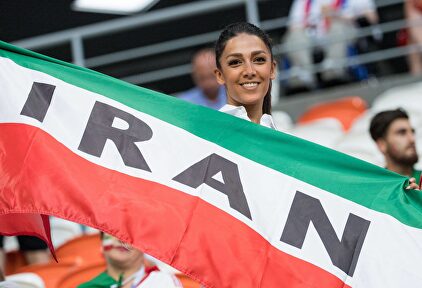 Una joven aficionada posa con la bandera de Irán durante un partido de fútbol. |  Cordon Press