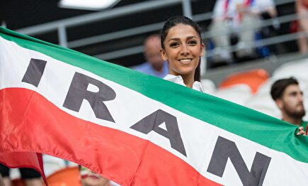 Una joven aficionada posa con la bandera de Irán durante un partido de fútbol. |  Cordon Press