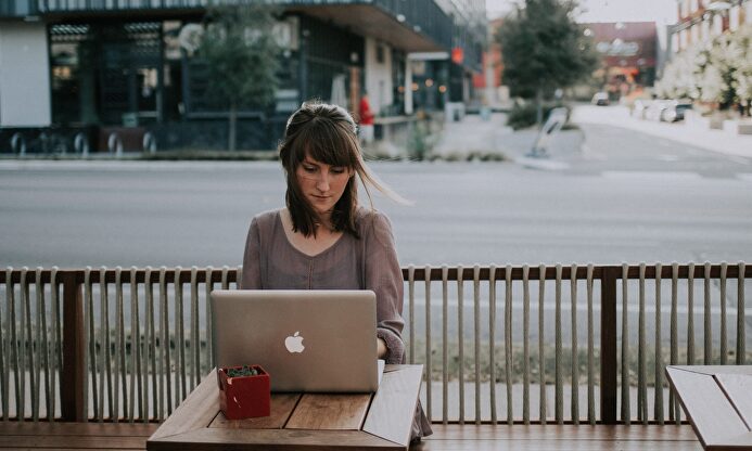 Una usuaria comparte su dispositivo con la red wifi de una cafetería | Banco de imágenes