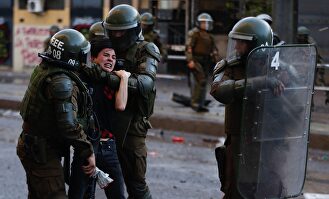 Fuerzas Especiales de Carabineros detienen a un manifestante. |  EFE