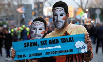 Separatistas de Tsunami con la careta de Messi y la pancarta 'Spain. Sit and talk'. |  EFE