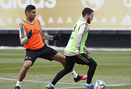 Hazard conduce la pelota en el entrenamiento ante Casemiro. | Realmadrid.com
