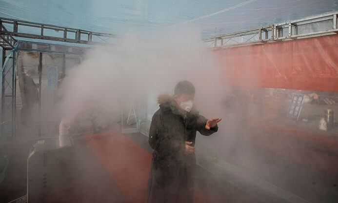 Una persona atraviesa una zona de desinfección en China. |  EFE