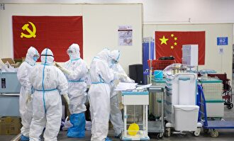 Personal médico con trajes protectores trabajando en el hospital provisional de Wuhan. |  EFE