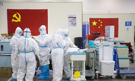 Personal médico con trajes protectores trabajando en el hospital provisional de Wuhan. | EFE