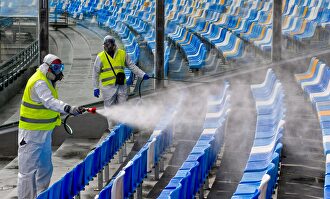 Operarios limpian un estadio de fútbol. | EFE