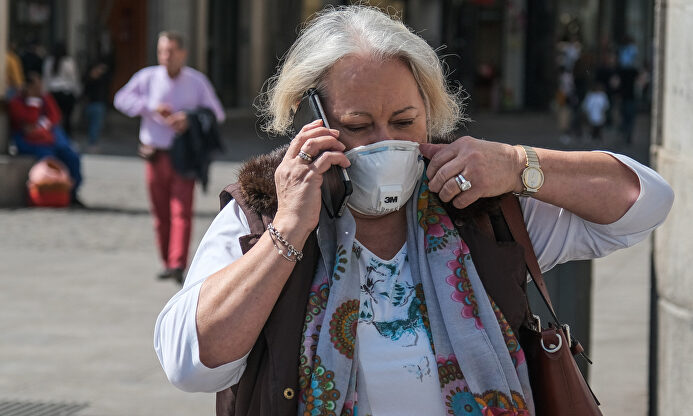 Una mujer camina por la calle con mascarilla. | Cordon Press