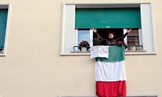 Una mujer se asoma a su ventana durante el confinamiento que se decretó en Italia. | EFE