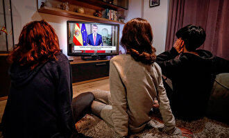 Unos niños siguiendo el mensaje del Rey. | EFE