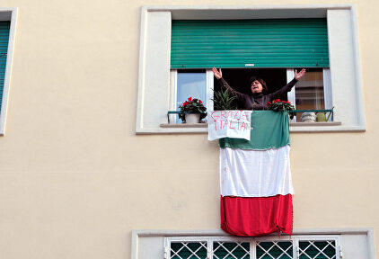 Una mujer se asoma a la ventana durante el confinamiento decretado en Italia. | Mauro Scrobogna/LaPresse