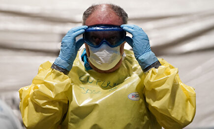 Un sanitario se coloca el equipo de protección | Comunidad de Madrid