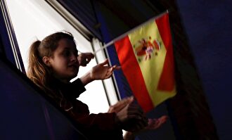 Una joven aplaude desde su balcón. | EFE