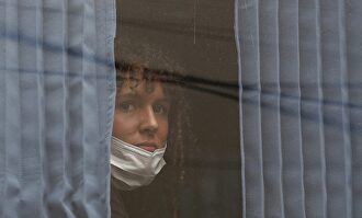 Una mujer es vista en el bus que llevará a ciudadanos canadienses que viven en Lima al aeropuerto, este martes. | EFE