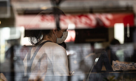 Una trabajadora con mascarilla en un comercio de Barcelona. | EFE