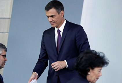 Oliver, sentado, junto a Pedro Sánchez en una imagen de archivo. | EFE