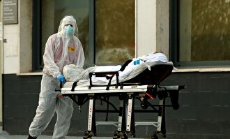 Un técnico sanitario traslada a un paciente al Hospital. | EFE