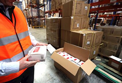 Un operario muestra los test rápidos recibidos. | EFE